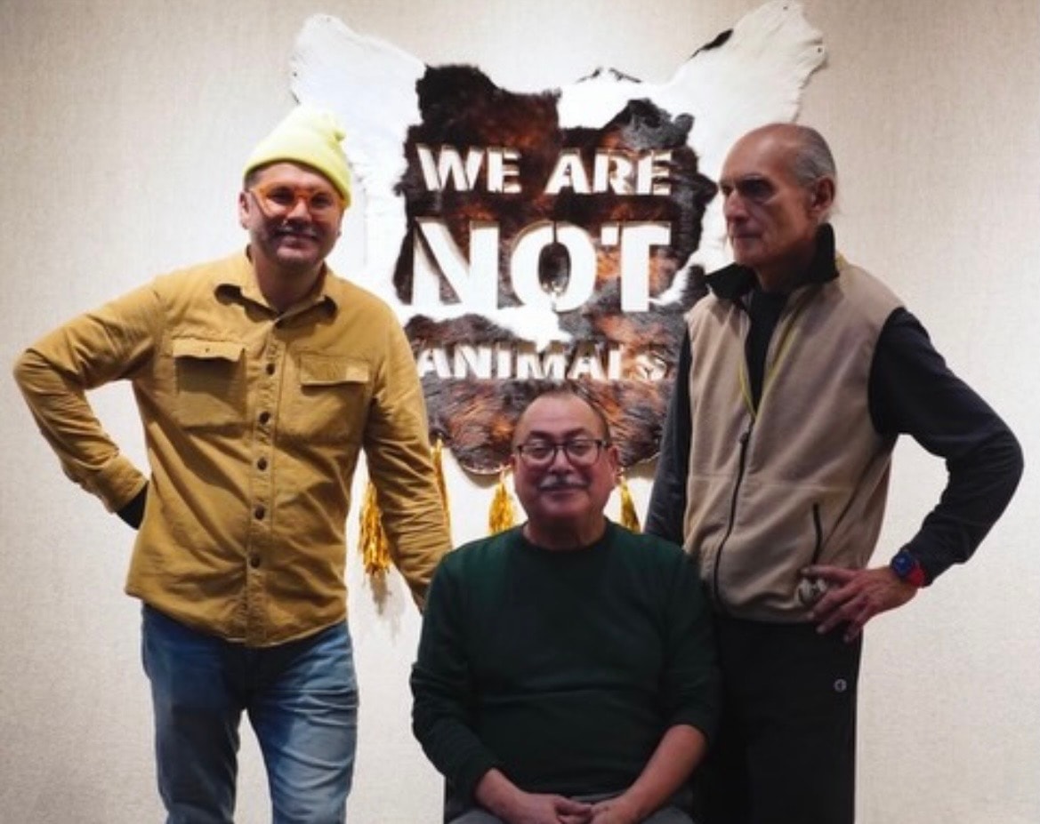 We Are Not Animals — Salvador Jiménez Flores, Ricardo Santos Hernández, and Gabriel Villa at the ChingARTE exhibition, Christopher Gallery, Prairie State College, Chicago Heights, IL. March 17 – April 14, 2026. The three Poets of Defiance together in front of Salvador's iconic work — a hide bearing the declaration that has defined their collective voice. Curated by Javier Chavira. by Ricardo Santos Hernández