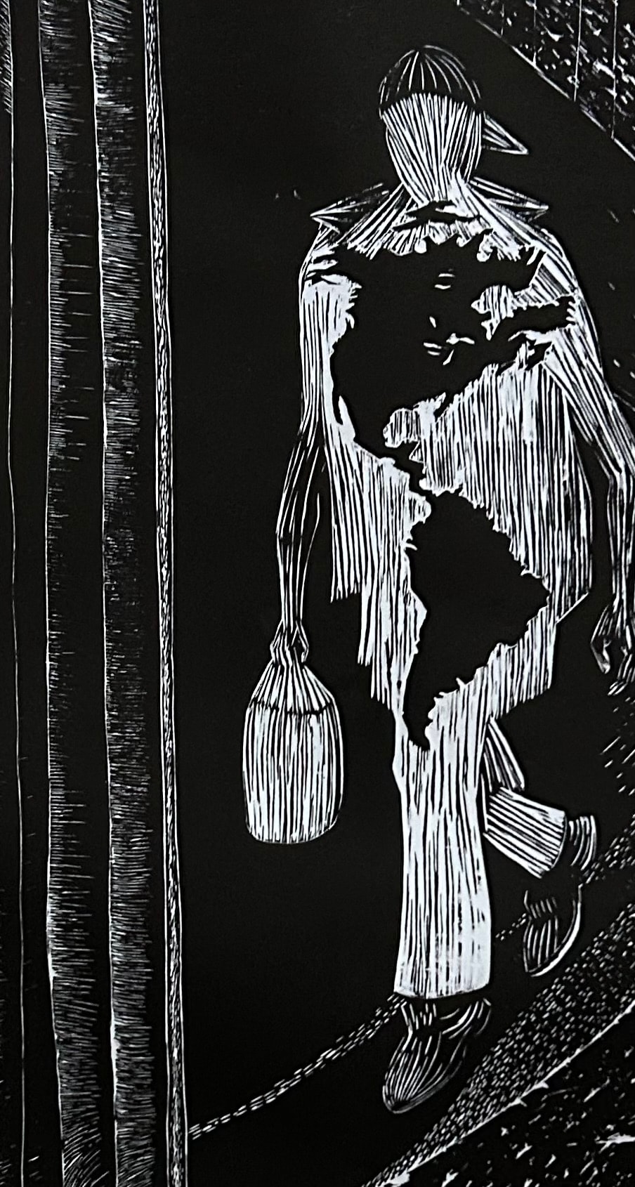 Hombre Cósmico: America Is Our DNA — Ricardo Santos Hernández. Linoleum print, printed at Rene Arceo's print shop, Oak Park, Illinois. The Hombre Cósmico strides forward — bag in hand, body carved from the block in bold white lines against absolute black. Across his chest and torso, the shape of the Americas emerges: the continent is not something he carries, it is something he is made of. A face looks out from within the landmass — a presence embedded in the geography, in the body, in the DNA. The linoleum cut gives the work its force: every line gouged by hand, every mark a decision. Printed in collaboration with master printmaker Rene Arceo, whose Oak Park studio has long been a home for Chicano printmaking and the visual traditions of resistance. by Ricardo Santos Hernández